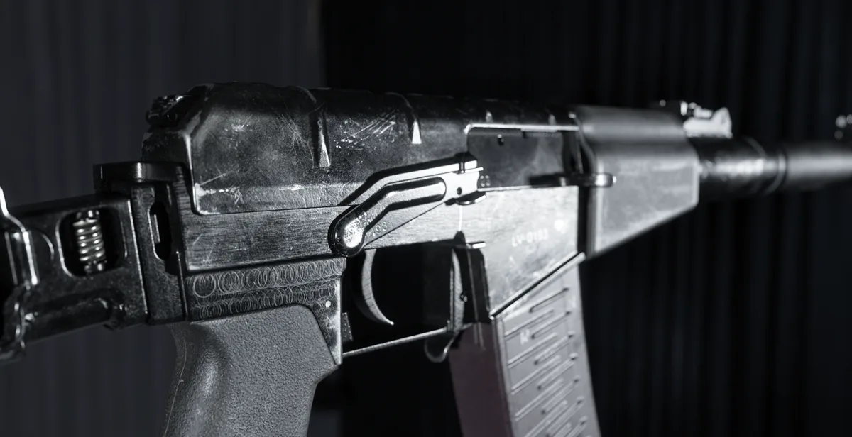 Official render: a close view of a suppressed rifle receiver and magazine against a dark backdrop.